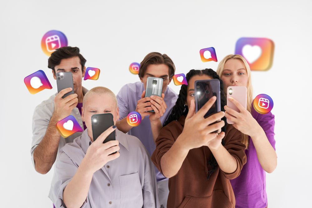 Grupo de jovens criando conteúdo com smartphones, representando estratégias de tráfego no Instagram com foco em engajamento e alcance.