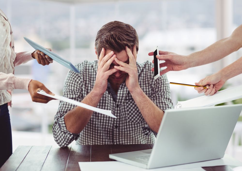 Empreendedor estressado cercado por tarefas, simbolizando erros que impedem seu negócio de crescer por falta de organização e foco.