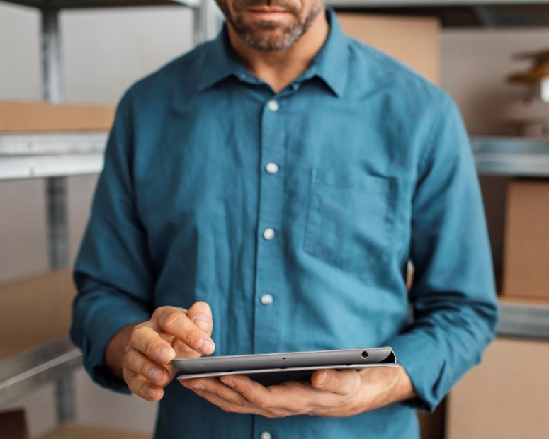 Homem confere em um tablet seu estoque virtual